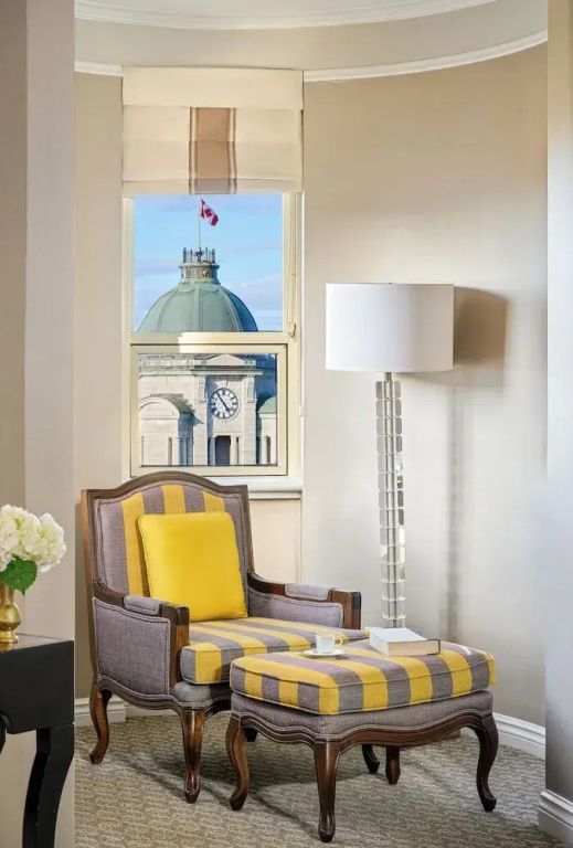 Kuschelige Sitzecke in der Frontenac Suite mit Ausblick auf historische Architektur.
