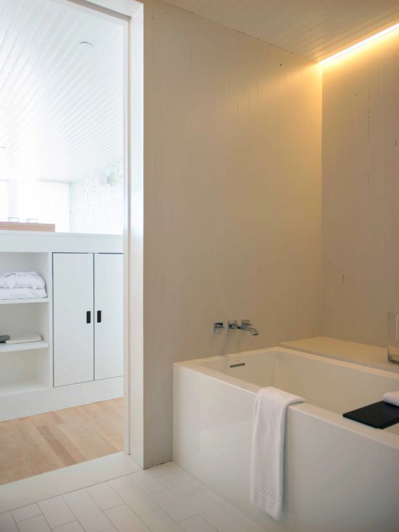 Moderne Badewanne in heller Familiensuite mit Handtüchern