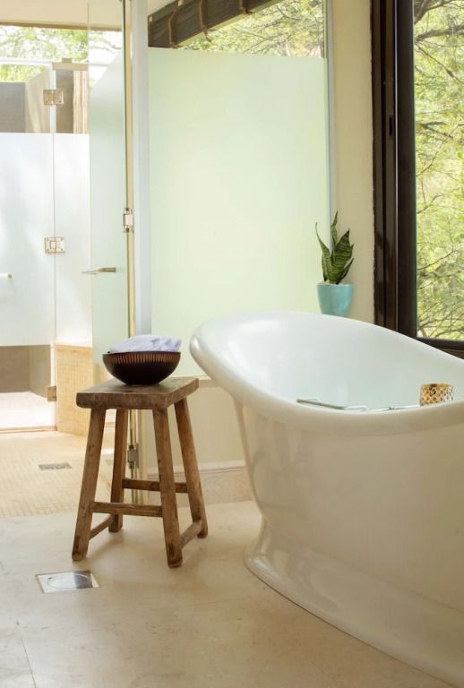 Luxuriöses Badezimmer mit freistehender Badewanne und Naturblick