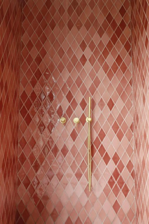 Rosa geflieste Dusche mit goldener Armatur