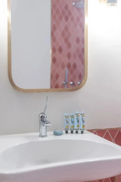 Badezimmerdetail mit Spiegel und Pflegeprodukten auf einem Waschbecken