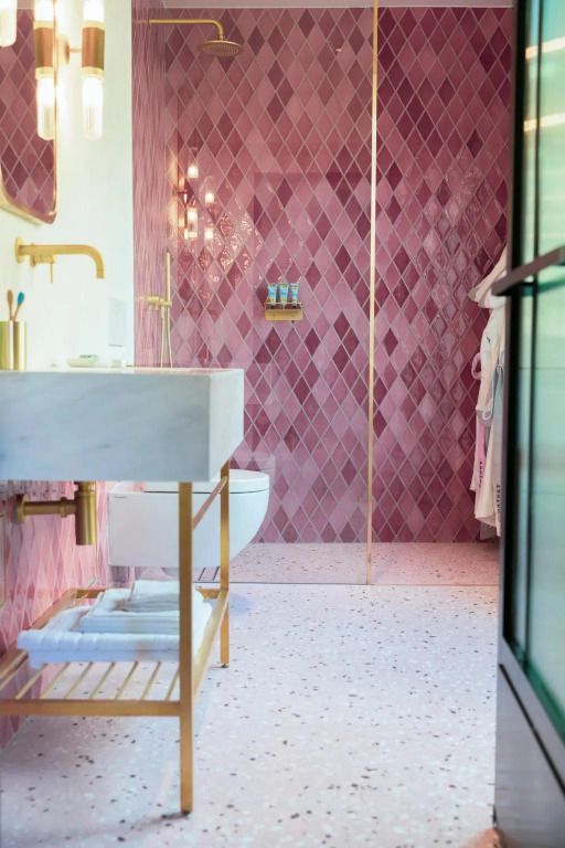 Luxuriöses Badezimmer mit rosa Fliesen und edler Regendusche im Hotel