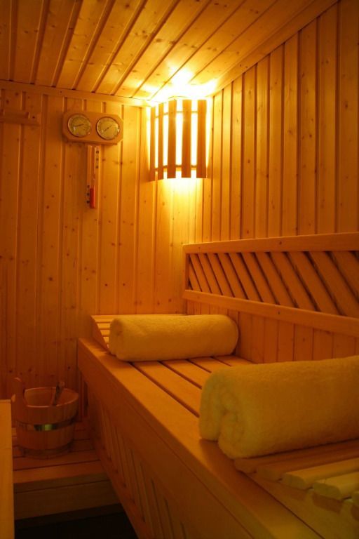 Sauna mit Holzbänken und warmem Licht in der Spa Suite