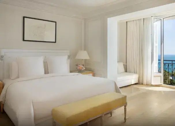 Elegantes Hotelzimmer mit Doppelbett, heller Einrichtung und Sitzecke