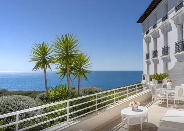 Traumhafte Terrasse mit Meerblick und Palmen am Horizont