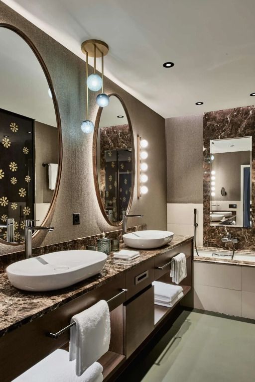 Luxuriöses Badezimmer mit Doppelwaschbecken und ovalen Spiegeln