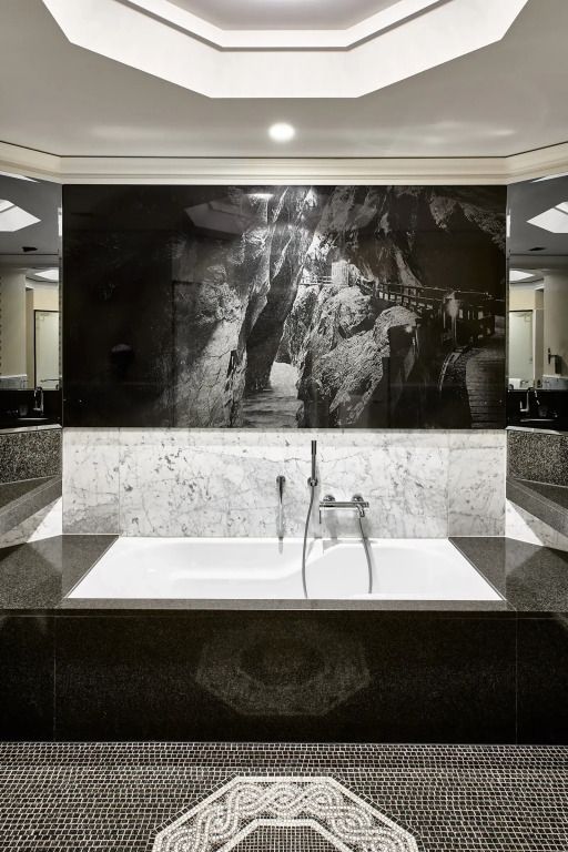 Großzügige Badewanne im eleganten Badezimmer mit kunstvoller Wandgestaltung