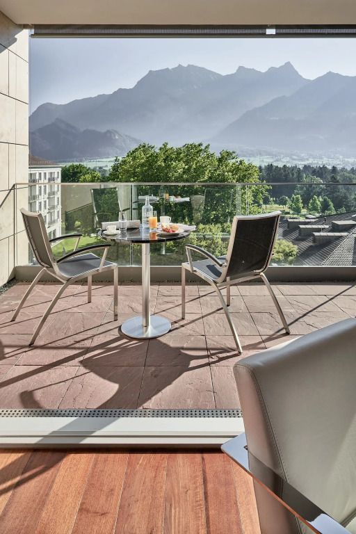 Balkon mit Tisch und Stühlen und Blick auf die umliegende Landschaft und Berge
