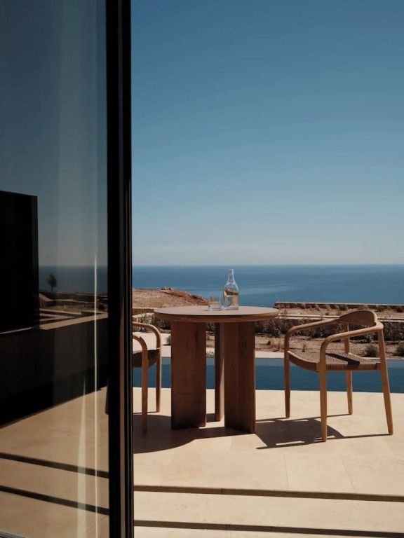 Privater Balkon mit zwei Stühlen und Tisch vor Meerespanorama