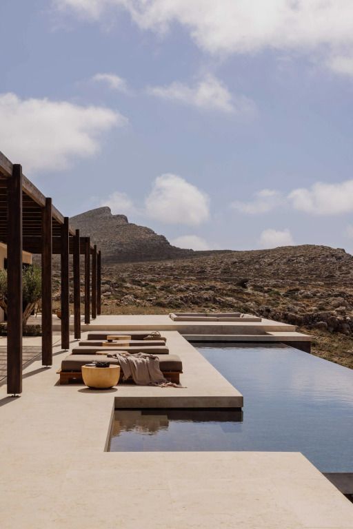 Infinity Pool mit Liegen und Blick auf die umgebende Berglandschaft