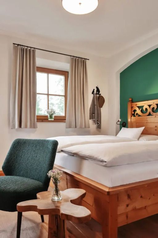 Gemütliches Doppelzimmer mit Holzvertäfelung und grüner Akzentwand