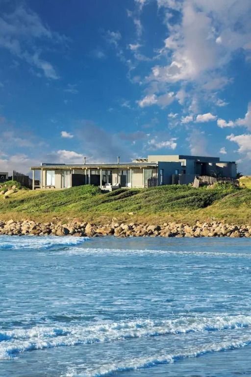 Hotelanlage am Meer mit blühender Landschaft und bewölktem Himmel