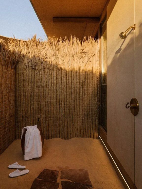Offene Dusche im Freien mit natürlichem Sichtschutz aus Schilfrohr