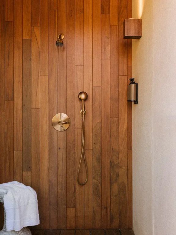 Holzverkleidete Dusche mit hochwertigen Armaturen