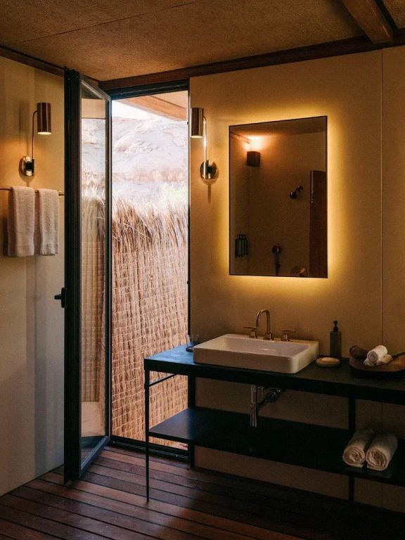 Modernes Badezimmer mit stilvoller Einrichtung und Lichtspiegel neben natürlicher Außensicht