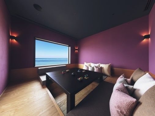 Gemütlicher Lounge-Bereich mit Blick auf das Meer durch ein großes Fenster