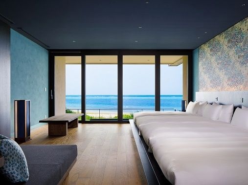 Luxuriöses Schlafzimmer mit Panoramafenstern und Meeresblick in der Suite.