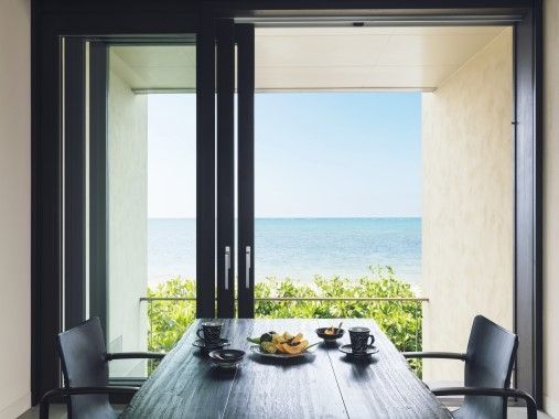 Essbereich mit Blick auf das Meer durch geöffnete Glastüren