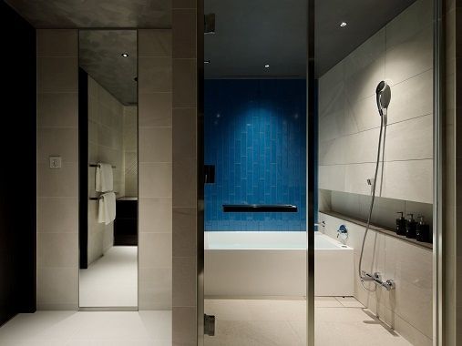 Modernes Badezimmer mit blauer Wandfliese und Badewanne