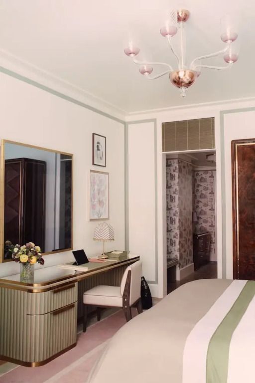 Elegantes Hotelzimmer mit Schreibtisch und Blumenarrangement in sanften Farben.