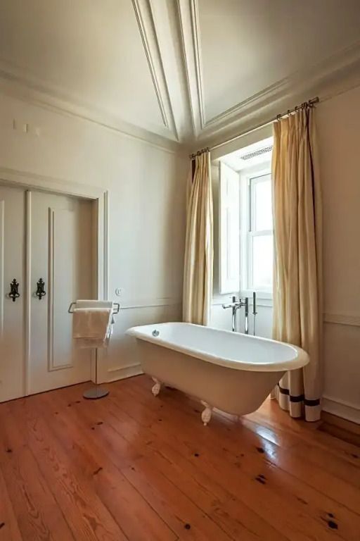 Freistehende Badewanne in schlichter Badezimmereinrichtung mit Vorhängen