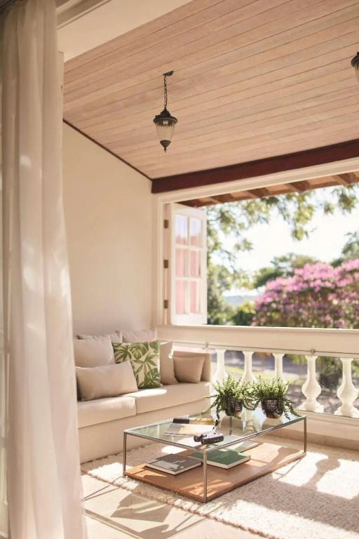 Gemütliche Veranda mit Sitzbereich und Blick auf blühende Natur.