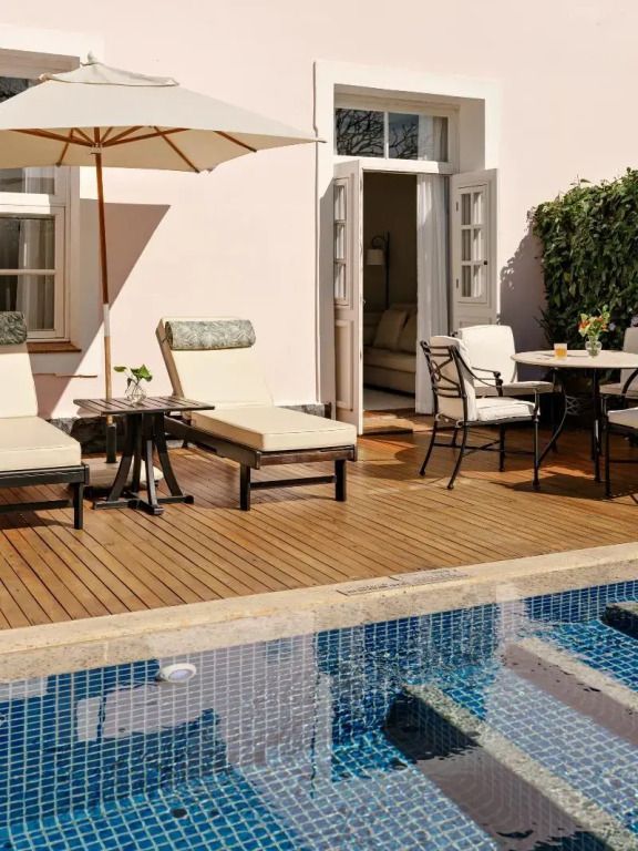 Terrasse mit Liegestühlen und Esstisch neben einem Pool