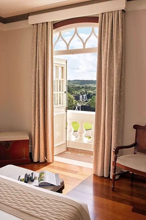 Zimmer mit offenem Balkon und Blick auf Wasserfälle und Natur
