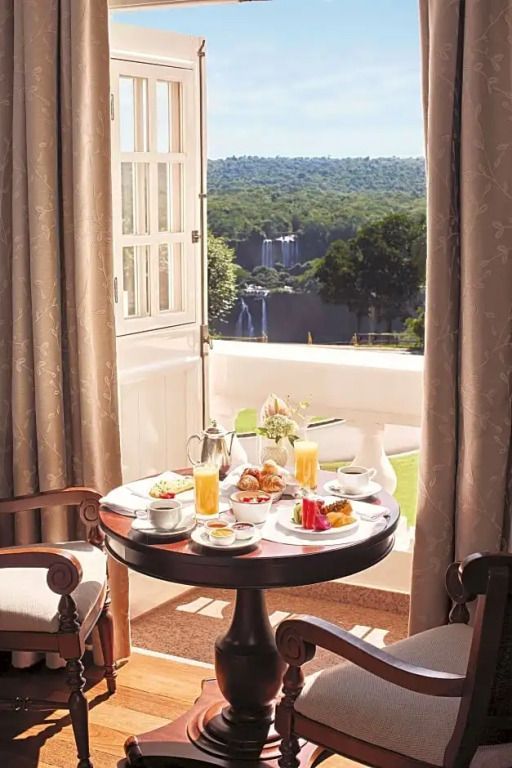 Frühstückstisch auf einem Balkon mit Blick auf Natur und Wasserfälle