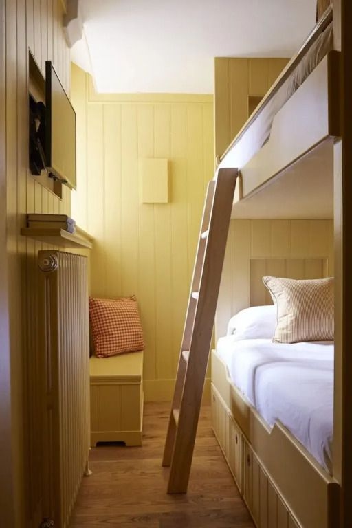 Kinderzimmer mit Etagenbett aus Holz und hellen Farben