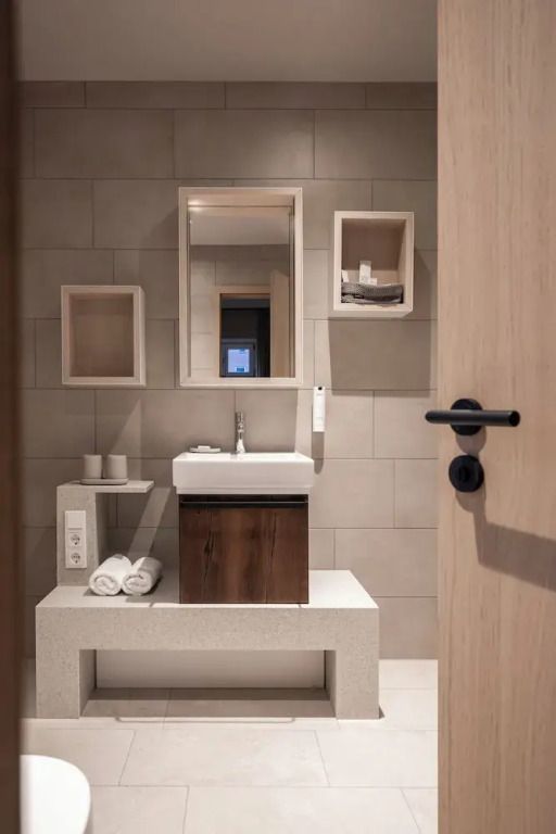 Modernes Badezimmer mit Waschbecken und Holzdetails im Hotelapartment