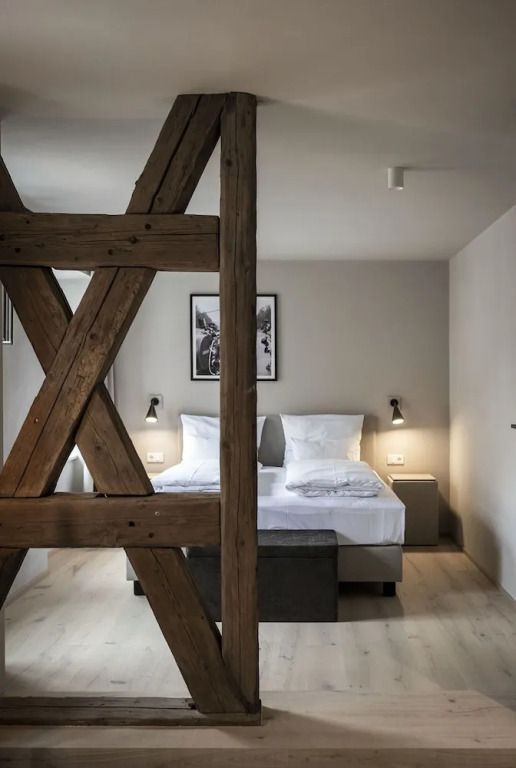 Komfort Suite mit Holzbalken und Doppelbett in neutralen Tönen
