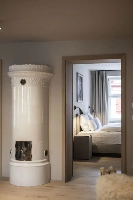 Komfort Suite Detail mit historischem Kachelofen und Durchsicht ins Schlafzimmer
