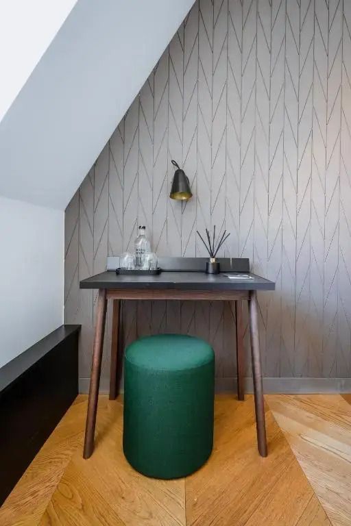Schreibtisch im Zimmer mit grüner Sitzgelegenheit