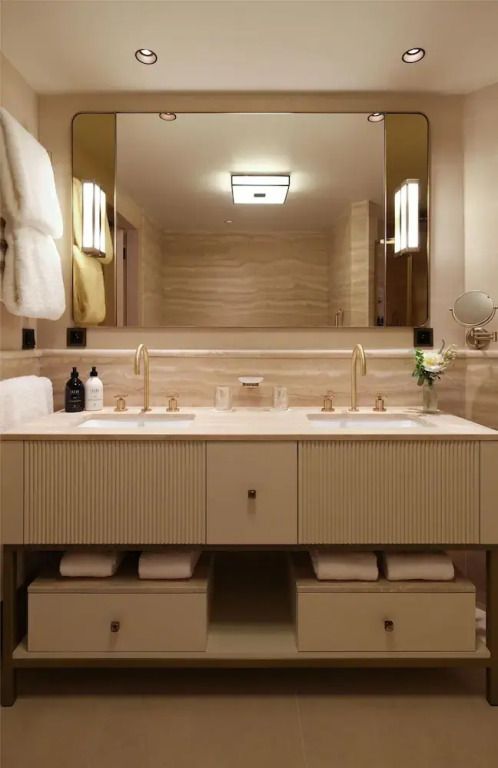 Luxuriöses Badezimmer mit Doppelwaschbecken und eleganter Beleuchtung in edlem Design.