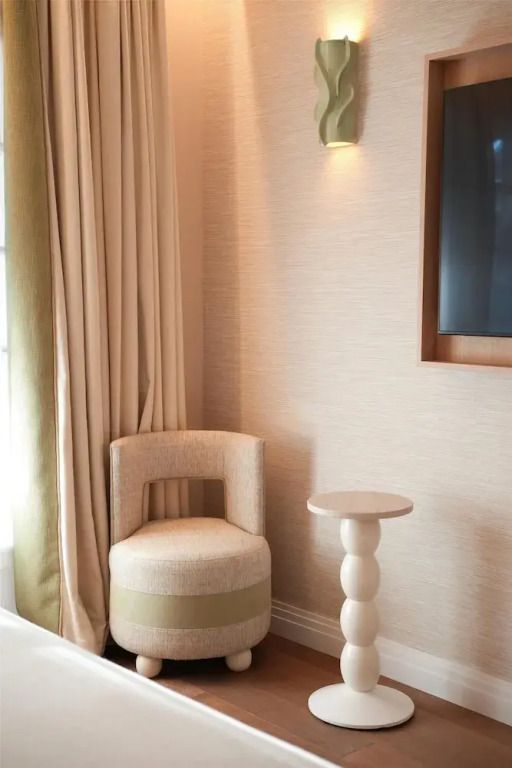Elegante Sitzecke im Zimmer mit dezenter Beleuchtung und stilvollen Vorhängen