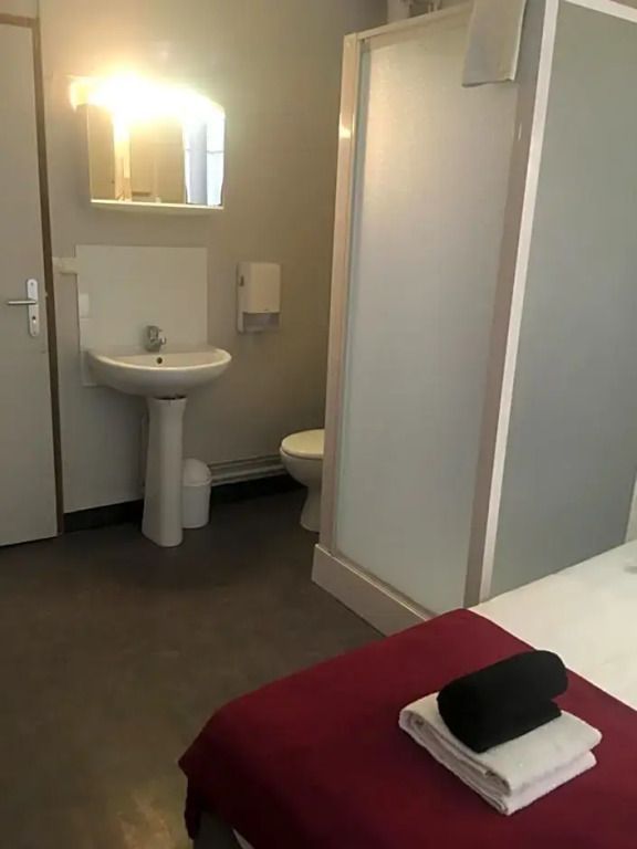 Hotelzimmer mit Dusche und Waschbecken im modernen Stil