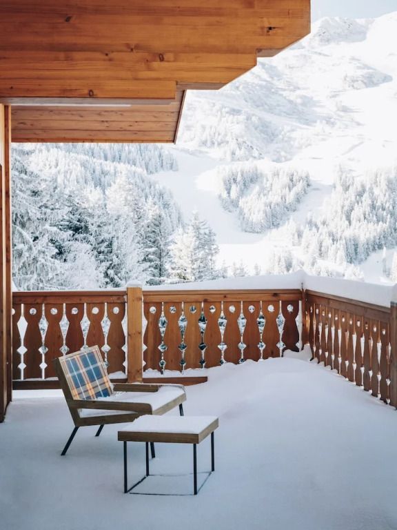 Verschneiter Balkon mit Blick auf die Berge und Waldlandschaft.