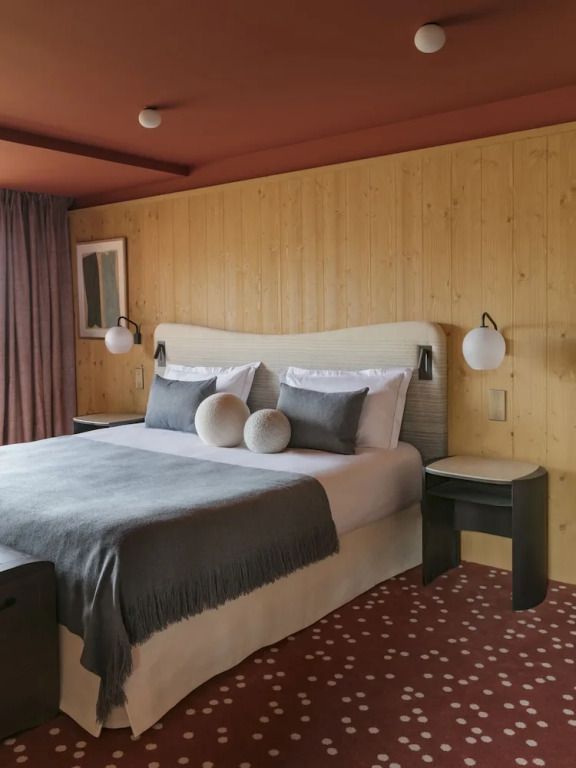 Gemütliche Superior Suite mit Holzwänden und Doppelbett im Hotel Le Coucou Méribel