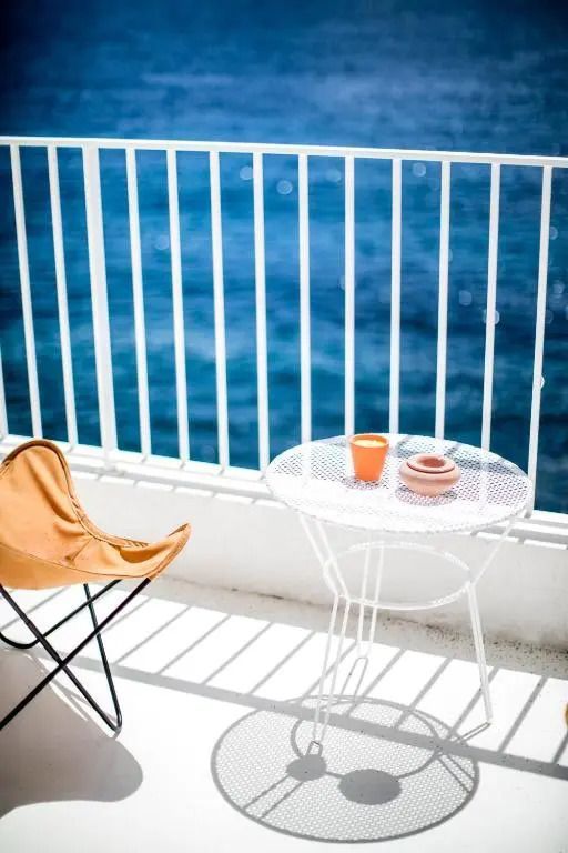 Balkon mit Tisch und Stuhl und Meeresblick