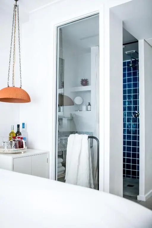 Zimmer mit Zugang zu Badezimmer und Dusche mit blauen Fliesen