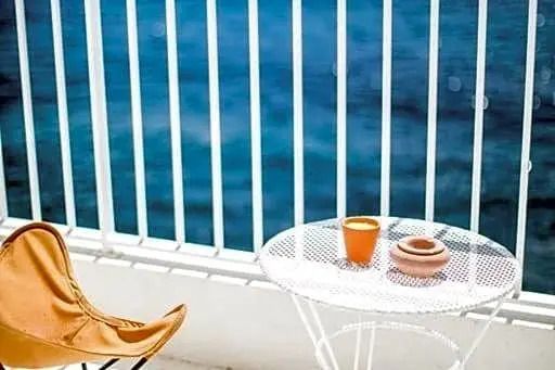 Privater Balkon mit Meerblick, weißen Möbeln und entspannender Atmosphäre