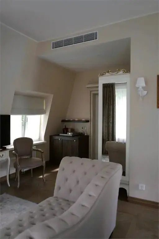 Avignon Suite mit Sitzbereich und großem Spiegel neben einem stylischen Schrank