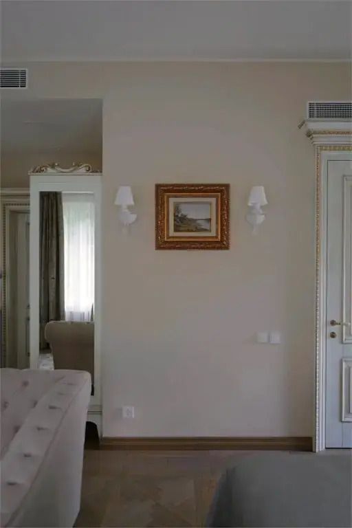Wanddekoration in der Avignon Suite mit Rahmen und dekorativen Leuchten