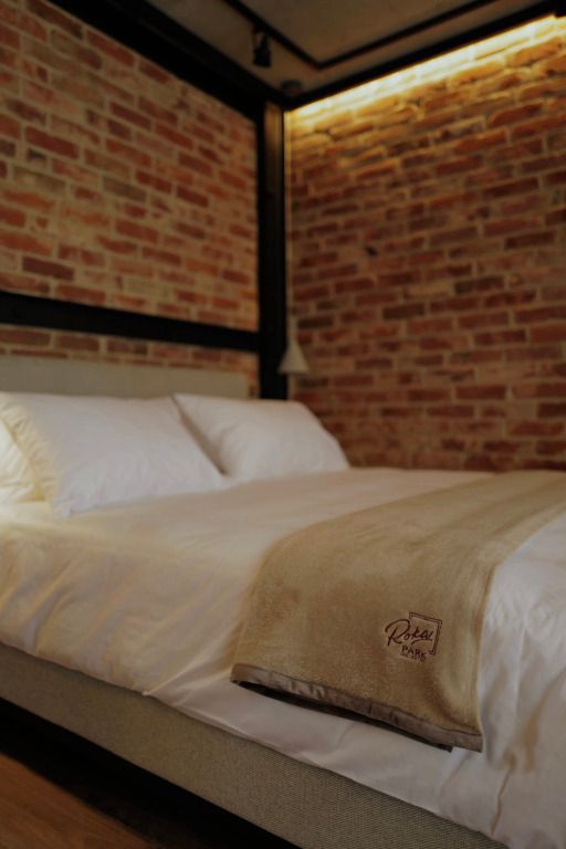 Gemütliches Doppelbett mit Backsteinwand im Hotelzimmer