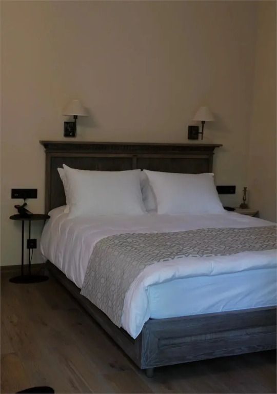 Luxuriöses Doppelbett mit weichen Kissen und Beleuchtung