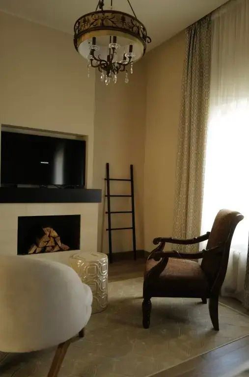 Zimmer mit Kamin, Fernseher und gemütlichem Sessel für entspannte Abende