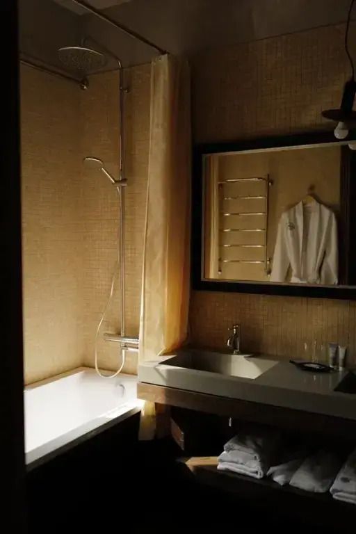 Modernes Badezimmer mit Badewanne und Spiegel in der Hannover Suite
