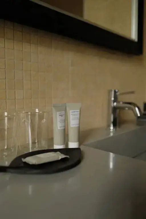 Pflegeprodukte und Waschbecken im Badezimmer der Hannover Suite