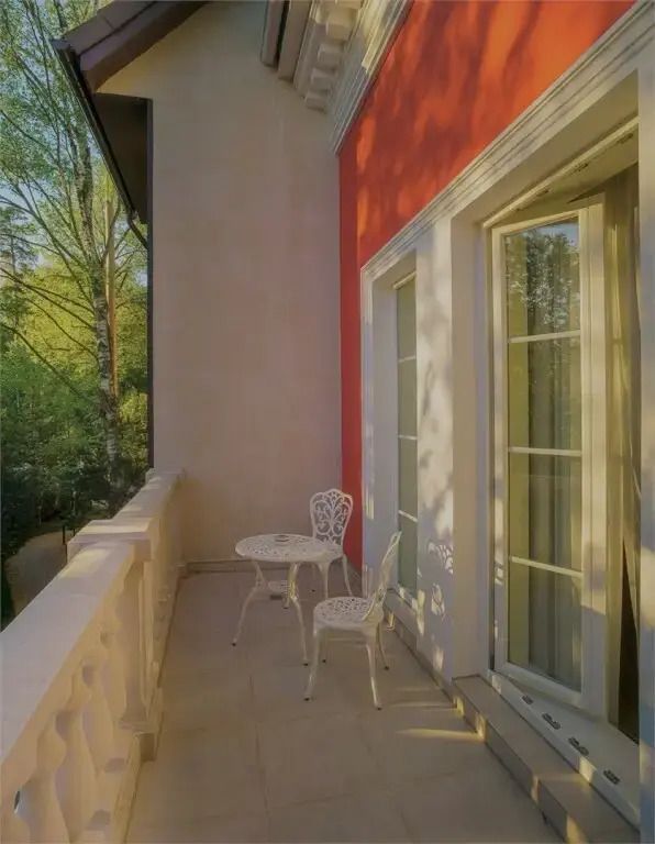 Sonnige Terrasse mit Möbeln und Blick ins Grüne